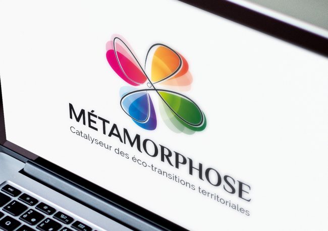 Logo Métamorphose, fleur multicolore, affiché sur un ordinateur portable