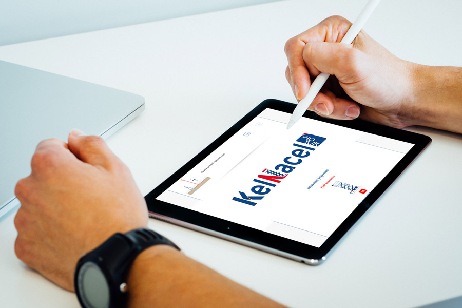 Main tenant un stylet sur une tablette affichant le site Kelnacel