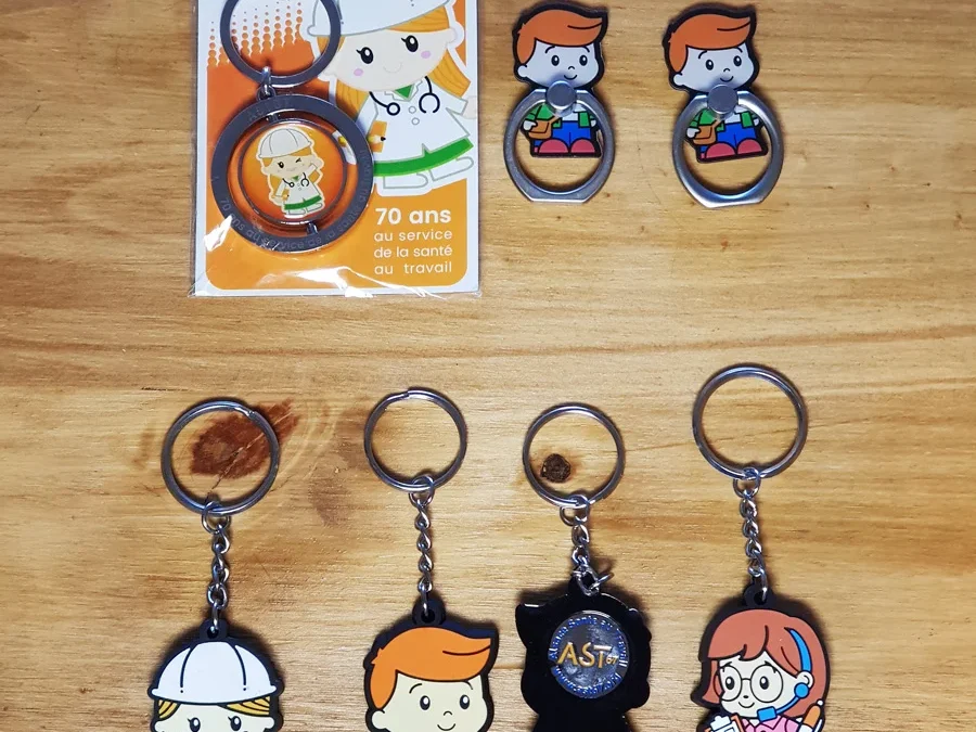 Porte-clés illustrés représentant une infirmière, un technicien de la santé et une standardiste, l'un retourné pour montrer le jeton de caddie, avec deux magnets et leur carte d'emballage AST67.